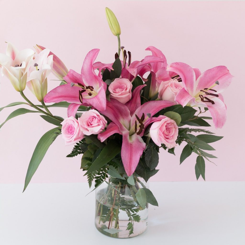 Bouquet of pink Lilies in a vase with roses