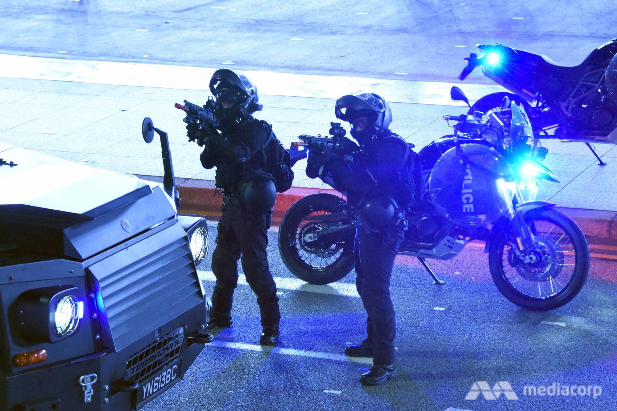 Rapid Deployment Troop officers aim their weapons at a "gunman" during a counter-terrorism exercise
