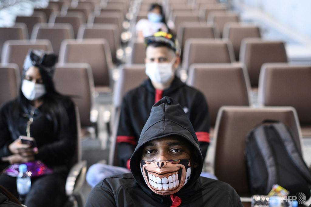 A man wearing a facemask sits at the Kai Tak cruise terminal